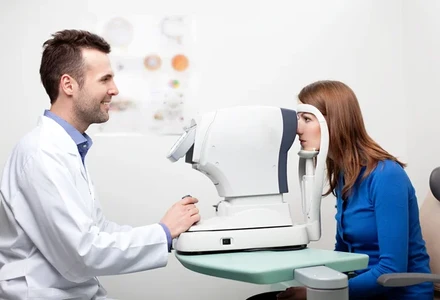 Patient undergoing automated eye exam with optometrist.